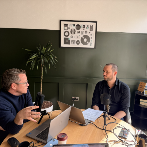 image of two men speaking inyto microphones